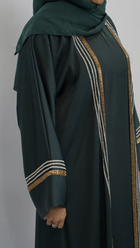 Elegant dark green abaya with gold and silver embellishments, featuring detailed sleeve and side stripes.